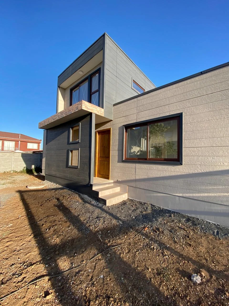 Vivienda contemporánea con revestimiento gris